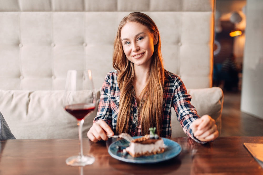 Frau im Cafe trinkt Wein zum Dessert - welche Geschmacksrichtung hat wohl der Wein?